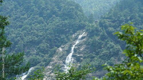 The beautiful countryside view with the waterfall flowing in the mountains after the rainy day