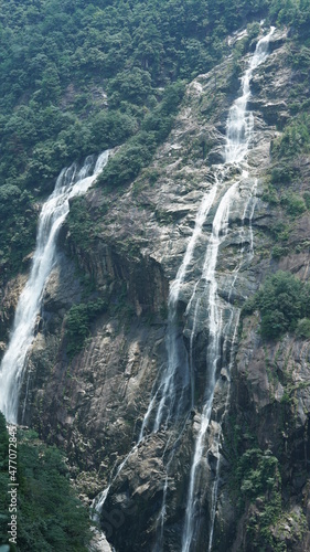 The beautiful countryside view with the waterfall flowing in the mountains after the rainy day