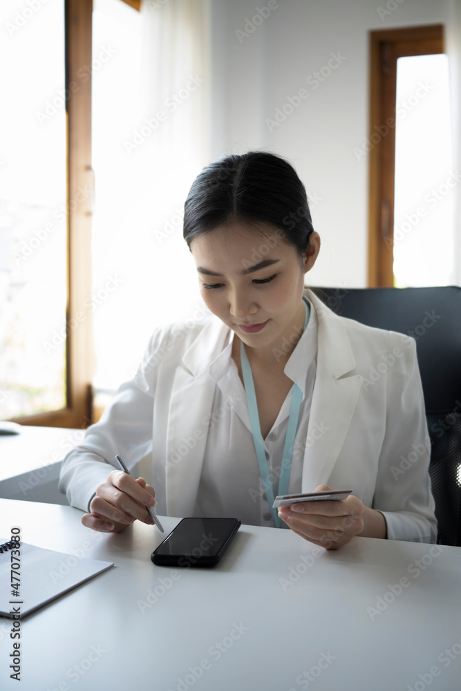 Asian businesswoman holding credit card and using smart phone for banking online. Asian businesswoman holding credit card and using smart phone for banking online.