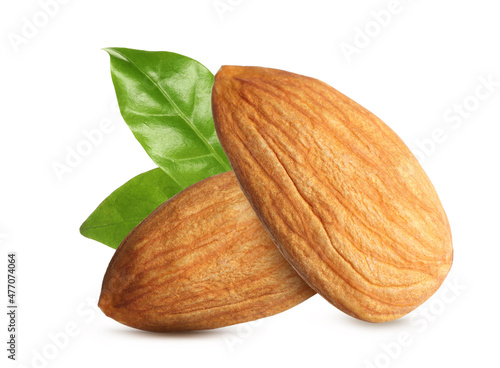 Tasty almonds and fresh green leaves on white background