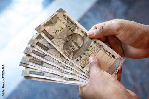 A woman counting Indian rupee notes of 500 photo