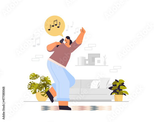 happy woman dancing and singing songs in microphone girl having fun living room interior horizontal