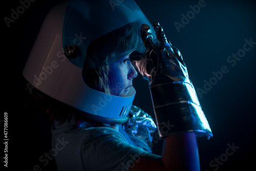 Close up kids portrait isolated on black, adventure imagination. Closeup face of little astronaut with helmet looking dreamily. Isolated background with copy space.