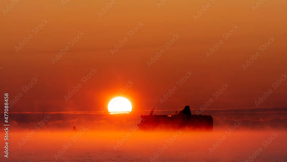 Sea Smoke over Gulf of Finland in front of Helsinki. Sun is setting while a ferry to Estonia passes by. One would be excused in thinking it is a tropical scene. Sea Smoke over Gulf of Finland in front of Helsinki. Sun is setting while a ferry to Estonia passes by. One would be excused in thinking it is a tropical scene.
