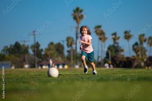 Kid playing soccer, happy child enjoying sports football game, kids activities, little soccer player. Kids play soccer game.