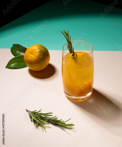 Citrus tea with yuzu zest in a glass and fruit on the table. Contrast frame, hard shadows.