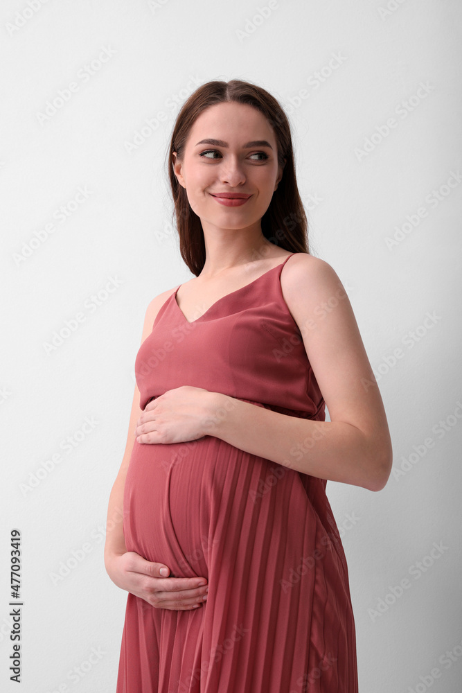 Beautiful young pregnant woman on light background Beautiful young pregnant woman on light background