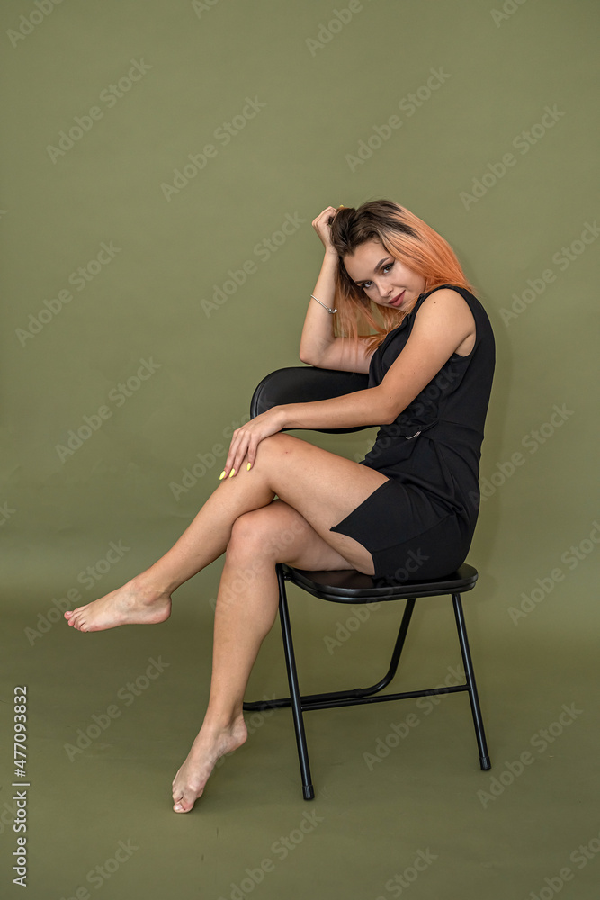 girl with perfect makeup well-groomed hair stylishly dressed poses on a solid background.