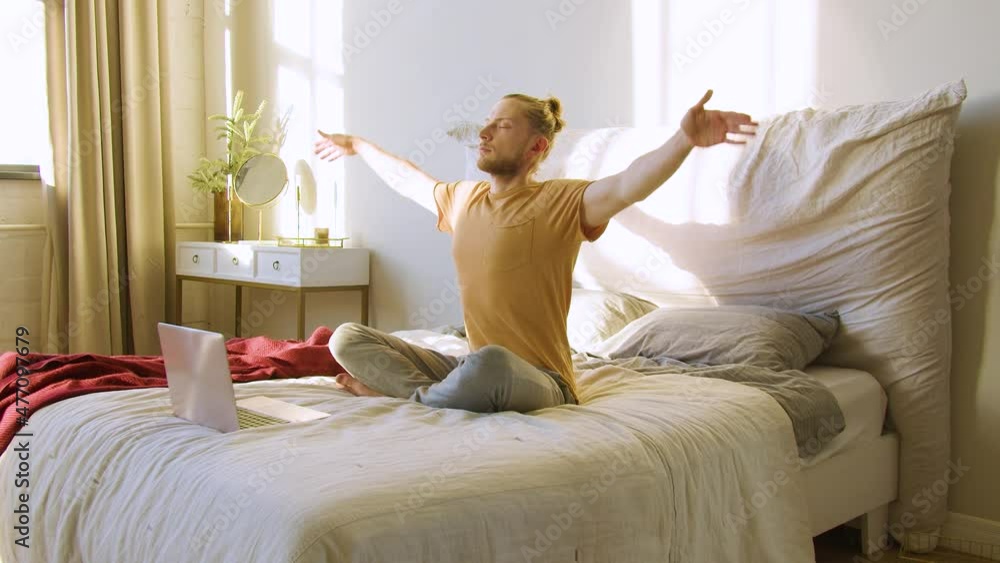 Yoga and Pilates Practice. Young red-haired man browses the internet for a meditation guide and begins to meditate. Yoga and Pilates Practice. Young red-haired man browses the internet for a meditation guide and begins to meditate.