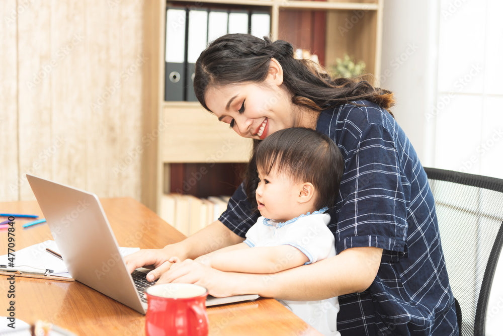 Beautiful Asian business mom is using a laptop while spending time with her cute baby boy at home for quarantine from virus crisis, work from home concept. Beautiful Asian business mom is using a laptop while spending time with her cute baby boy at home for quarantine from virus crisis, work from home concept.
