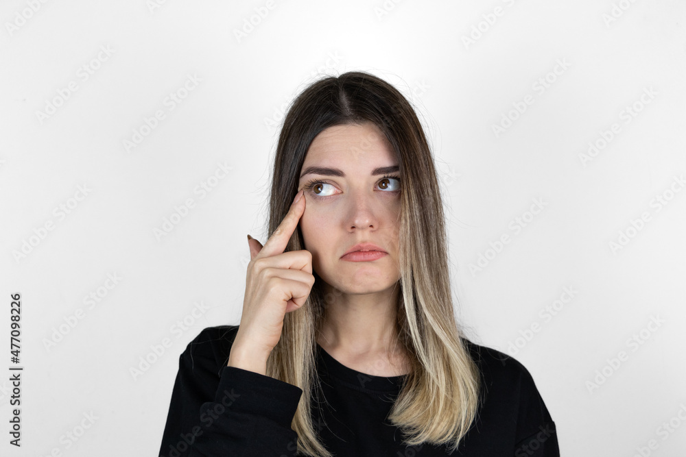 A woman in casual clothes is crying upset. Close up photo of sad girl with white background. A woman in casual clothes is crying upset. Close up photo of sad girl with white background.