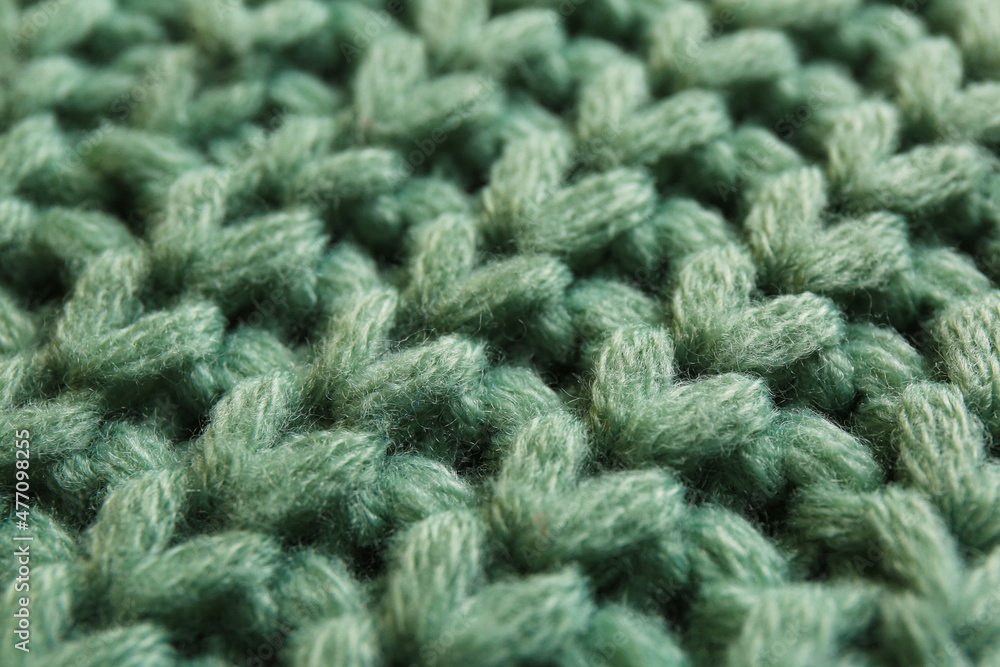 Beautiful pale green knitted fabric as background, closeup Beautiful pale green knitted fabric as background, closeup
