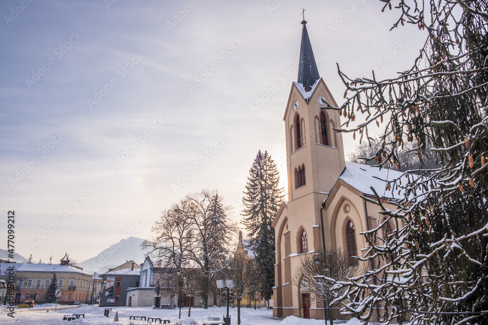 Dolny Kubin, Slovakia - December 26 2021: City centre of Dolny Kubin during Christmas time. Hviezdoslavov Square with towers of local churches. Snowy landscape and historic houses. Orava region