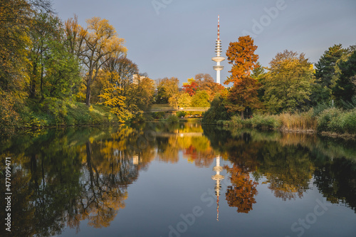 Germany, Hamburg, Autumn trees reflecting on surface of shiny lake in Wallanlagen park photo