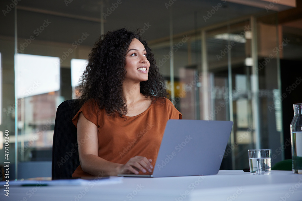 Happy businesswoman with laptop on desk day dreaming in office Happy businesswoman with laptop on desk day dreaming in office