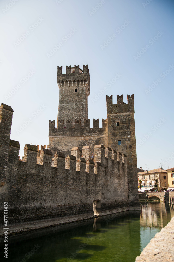 Scaliger castle is historical landmark of the city Sirmione in Italy on the lake Garda. Medieval Italian castle. The stone walls of an ancient tower on the background of blue sky