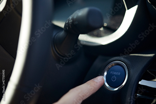 Businesswoman pointing at electric car start button photo