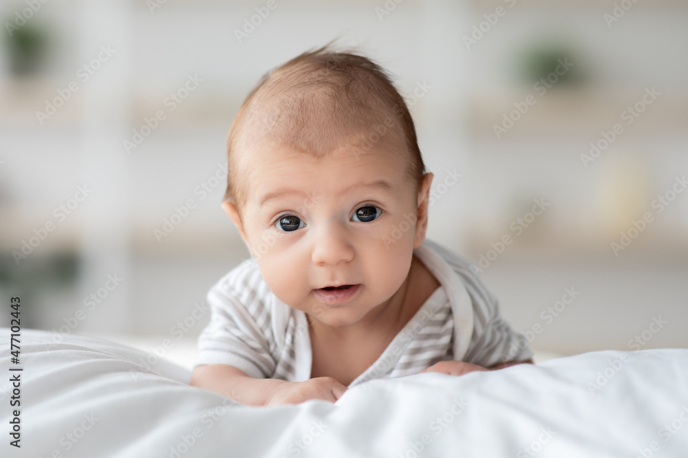 Cute Little Infant Child Lying On His Belly On Bed At Home Cute Little Infant Child Lying On His Belly On Bed At Home