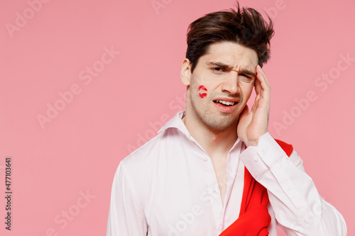 Fototapeta Young confused sad caucasian man 20s with lipstick lips on face wearing casual shirt sweater have headache isolated on pink background studio