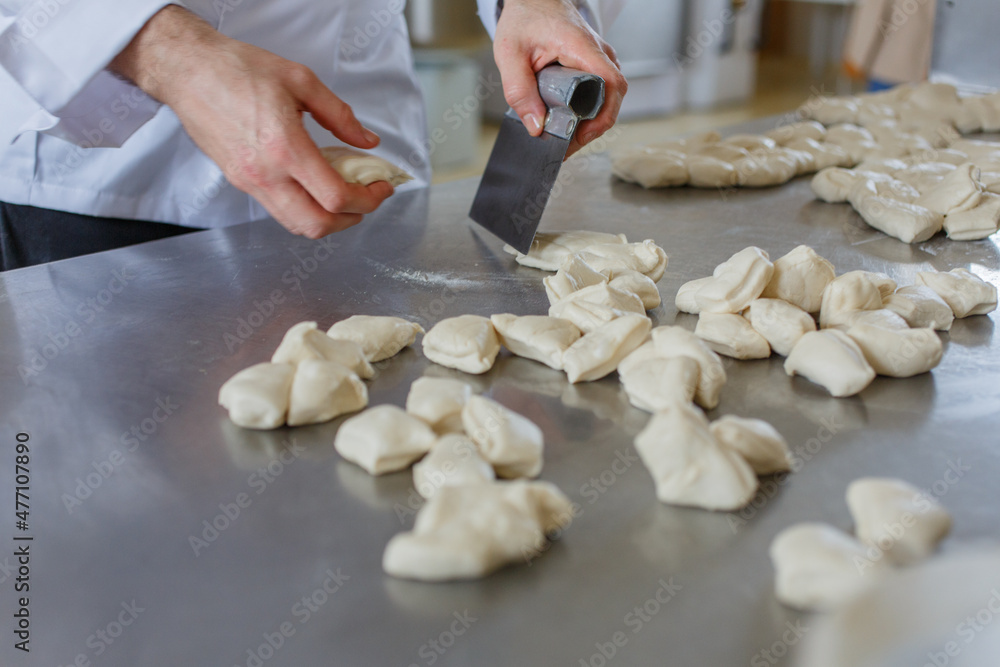 Panettiere mentre prepara i panetti di pane da infornare Panettiere mentre prepara i panetti di pane da infornare