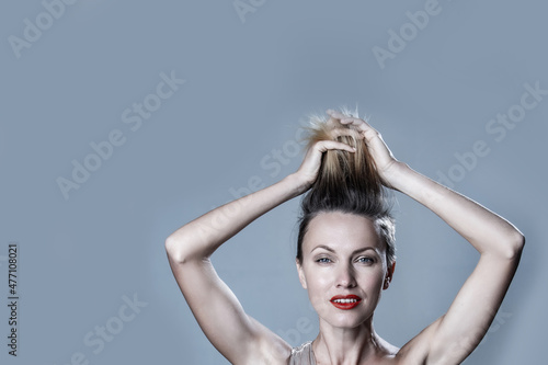 It is time to renew haircoloring. Beautiful woman showing her hair roots uncolored photo