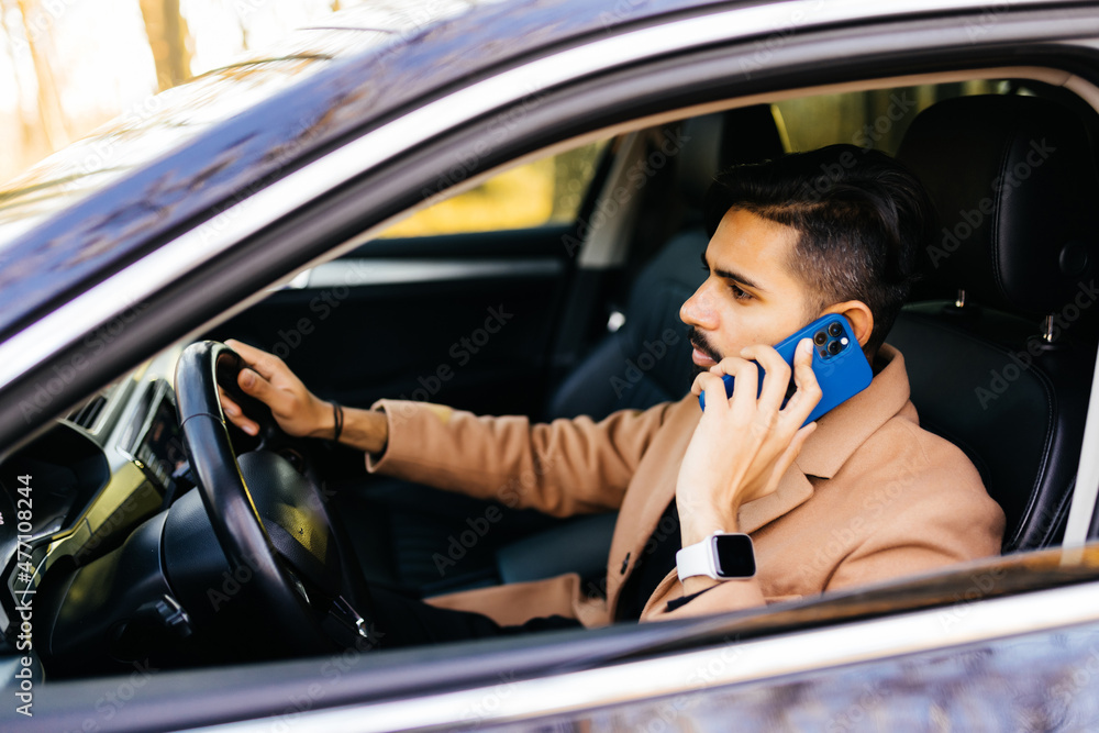 Indian Businessman talking on cell phone while driving and overtaking, not paying attention to the road and traffic Indian Businessman talking on cell phone while driving and overtaking, not paying attention to the road and traffic