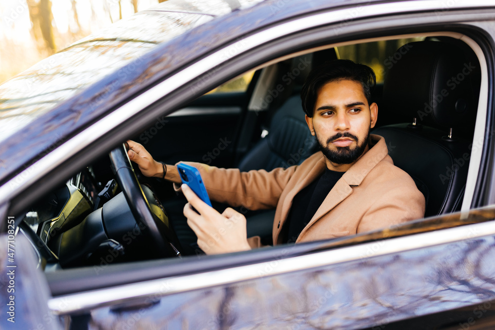 Business indian man use smart phone and drive an auto self-driving smart car in highway Business indian man use smart phone and drive an auto self-driving smart car in highway