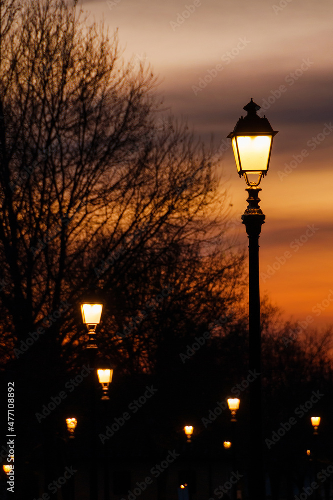 Winter and romance in Lucca. Anciet walls streetlights with sunset sky