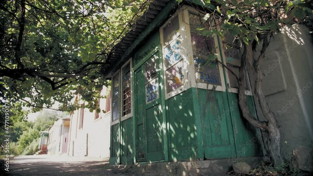 old abandoned wooden building. street vandalism. old abandoned wooden building, with painted graffiti inscriptions. summer sunny day. old abandoned wooden building. street vandalism. old abandoned wooden building, with painted graffiti inscriptions. summer sunny day.