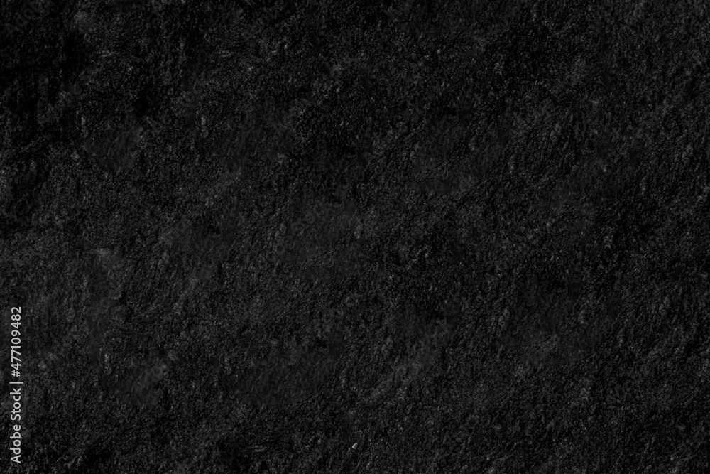 Fototapeta premium Many black stones arranged in layers looks mysterious. It may be a cave wall, used as a background, suitable for institutions and karma and design work, or suitable for geological work.