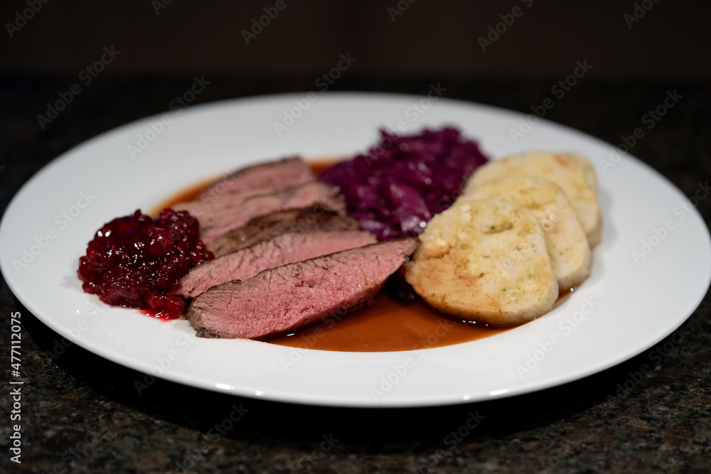 delicious meal from a young chamois with napkin dumplings and red cabbage, brown sauce and cranberries delicious meal from a young chamois with napkin dumplings and red cabbage, brown sauce and cranberries