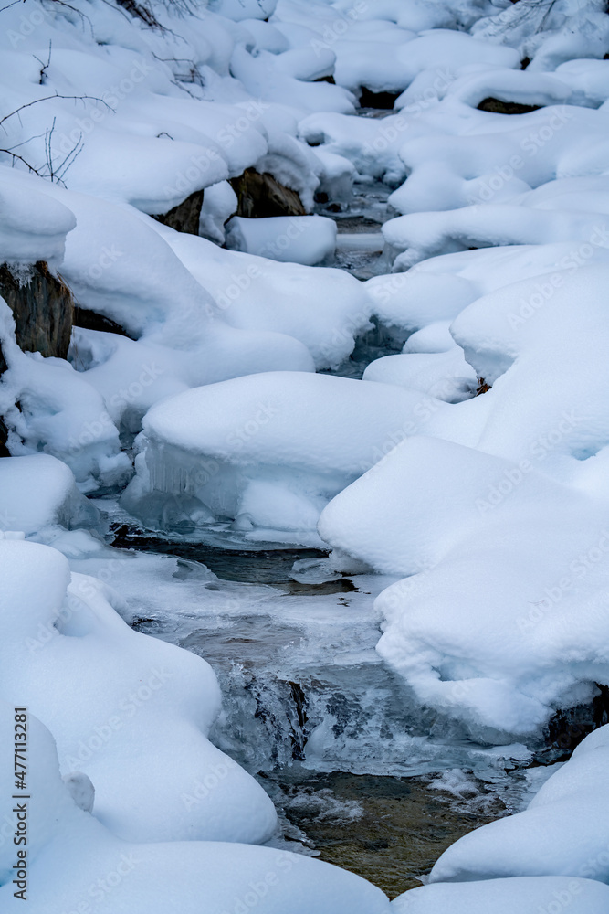 a small creek at a frosty, cold morning on the snow capped mountains a small creek at a frosty, cold morning on the snow capped mountains