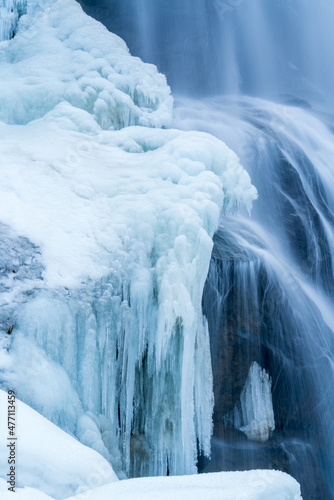 arctic landscape of frozen water from a waterfall in the mountains at a cold december day