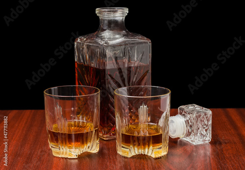 Whisky in two glasses and decanter on a wooden table