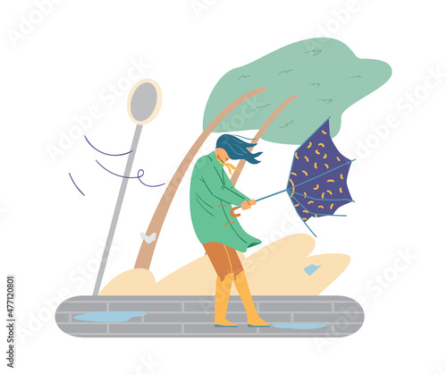 Girl, wearing raincoat and rubber boots with broken umbrella in her hands, walk in the street in wind and rain weather.