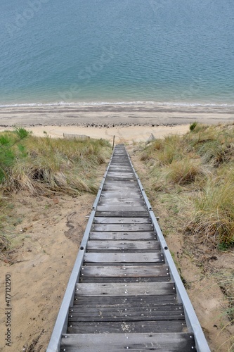 Big wooden stairs in the dunes to reach the sea. Gironde France