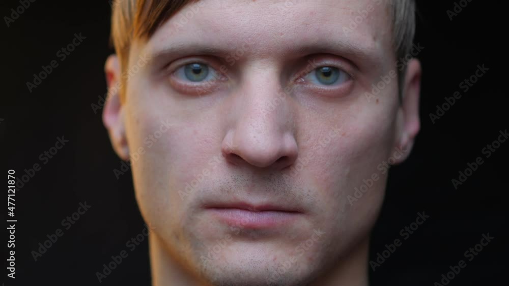 Young man look at the camera close up serious and smiling Young man look at the camera close up serious and smiling