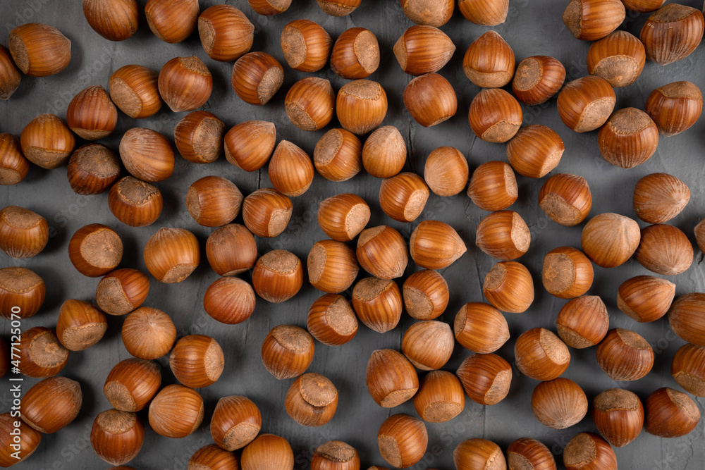 Peeled hazelnuts pattern, top view. Bio nuts on grau background. Peeled hazelnuts pattern, top view. Bio nuts on grau background.