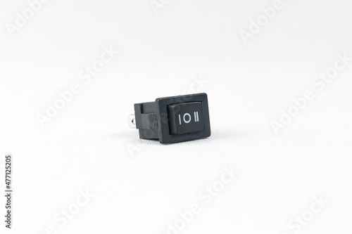 Black power switch, electronic component isolated on gray background