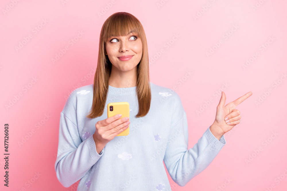Portrait of beautiful curious trendy cheerful girl using device demonstrating offer sale ad isolated over pink pastel color background Portrait of beautiful curious trendy cheerful girl using device demonstrating offer sale ad isolated over pink pastel color background