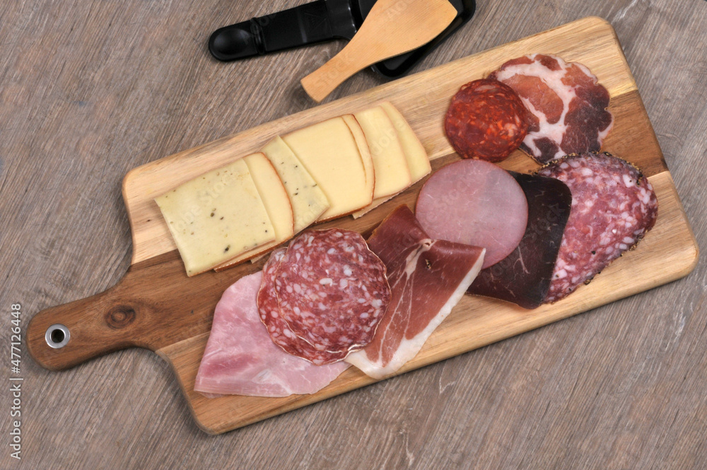 Assortiment de charcuterie pour faire une raclette sur une planche à