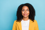 Photo of young black woman happy positive smile dream curious think look empty space isolated over blue color background