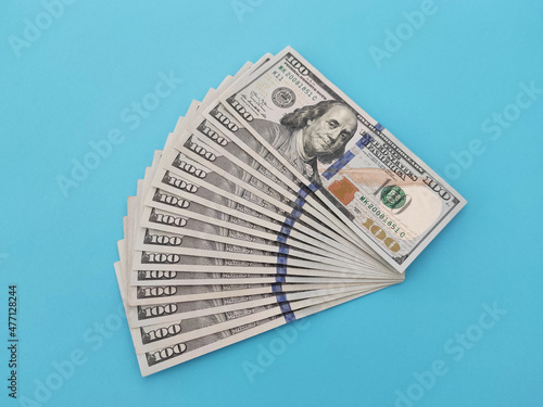 One hundred dollars bills on a blue background