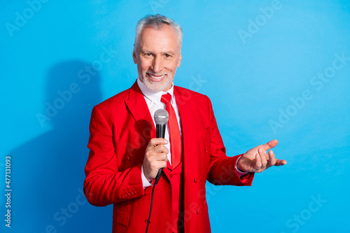 Photo of funny cheerful entertainer man hold microphone beaming smile wear red tux shoes isolated blue color background photo