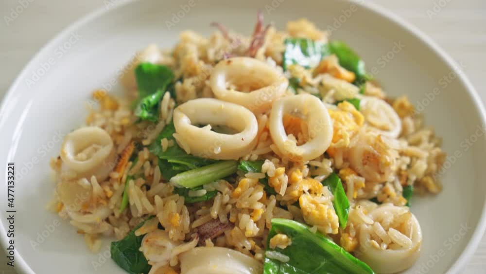 Fried rice with squid or octopus in bowl - stir-fried rice with squid, egg and kale Fried rice with squid or octopus in bowl - stir-fried rice with squid, egg and kale