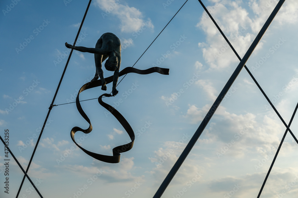 Obraz premium A sculpture of a human figure balancing on the ropes.