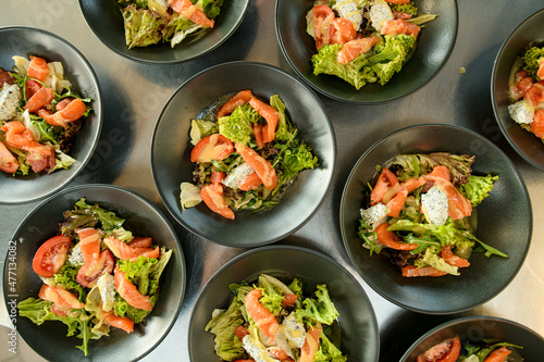 top view of plates with delicious salad with salmon greens and lettuce and tomatoes