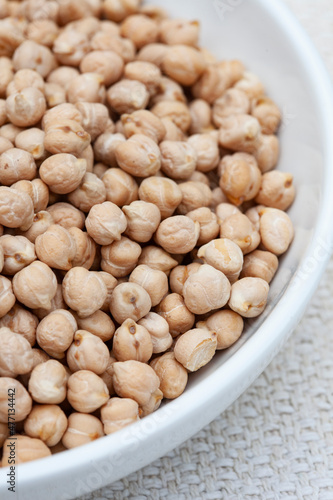 Bowl of Raw uncooked chickpeas on rustic surface