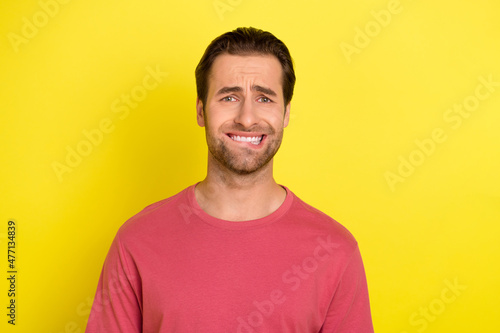 Photo of nervous guy bite lip struggle anxious thoughts wear pink t-shirt isolated yellow color background