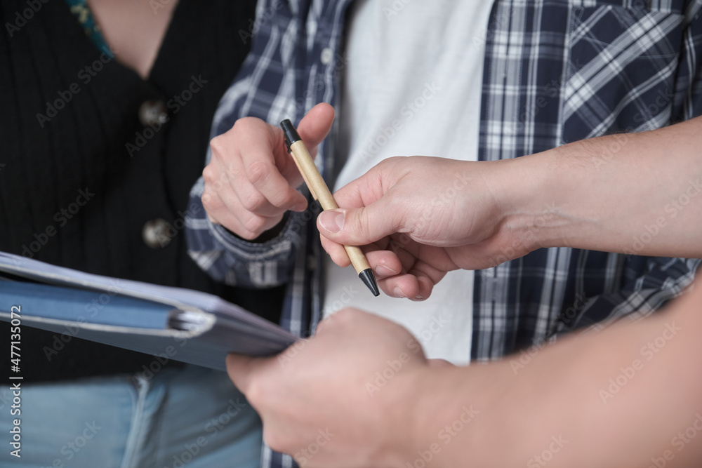 Detail of couple signing a document for buying house in construction. Detail of couple signing a document for buying house in construction.